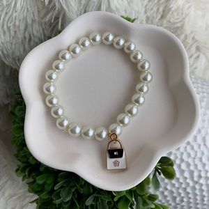 Faux pearl stretchy bracelet with mini purse charm